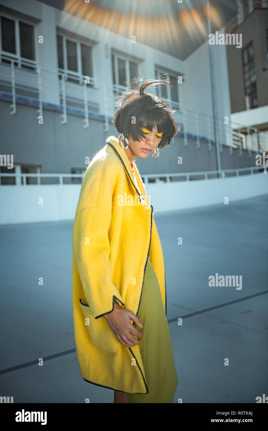 Unusual sloppy woman with wild hair wearing oversized coat Stock Photo