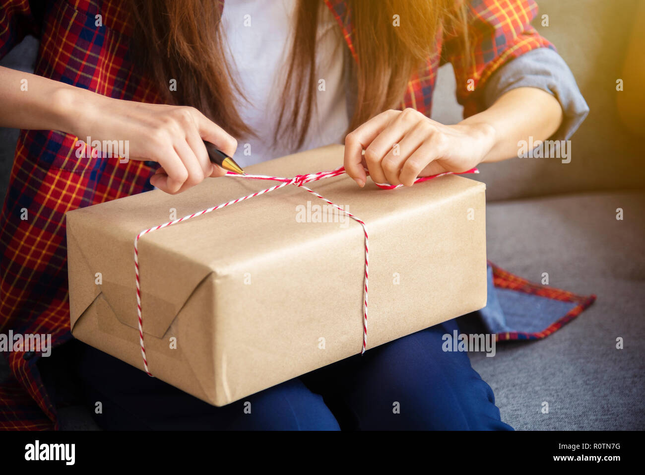 Small business, freelance online seller packing goods in box for deliver to customer. Can use for Merry Christmas, Happy New Year and Happy birthday c Stock Photo