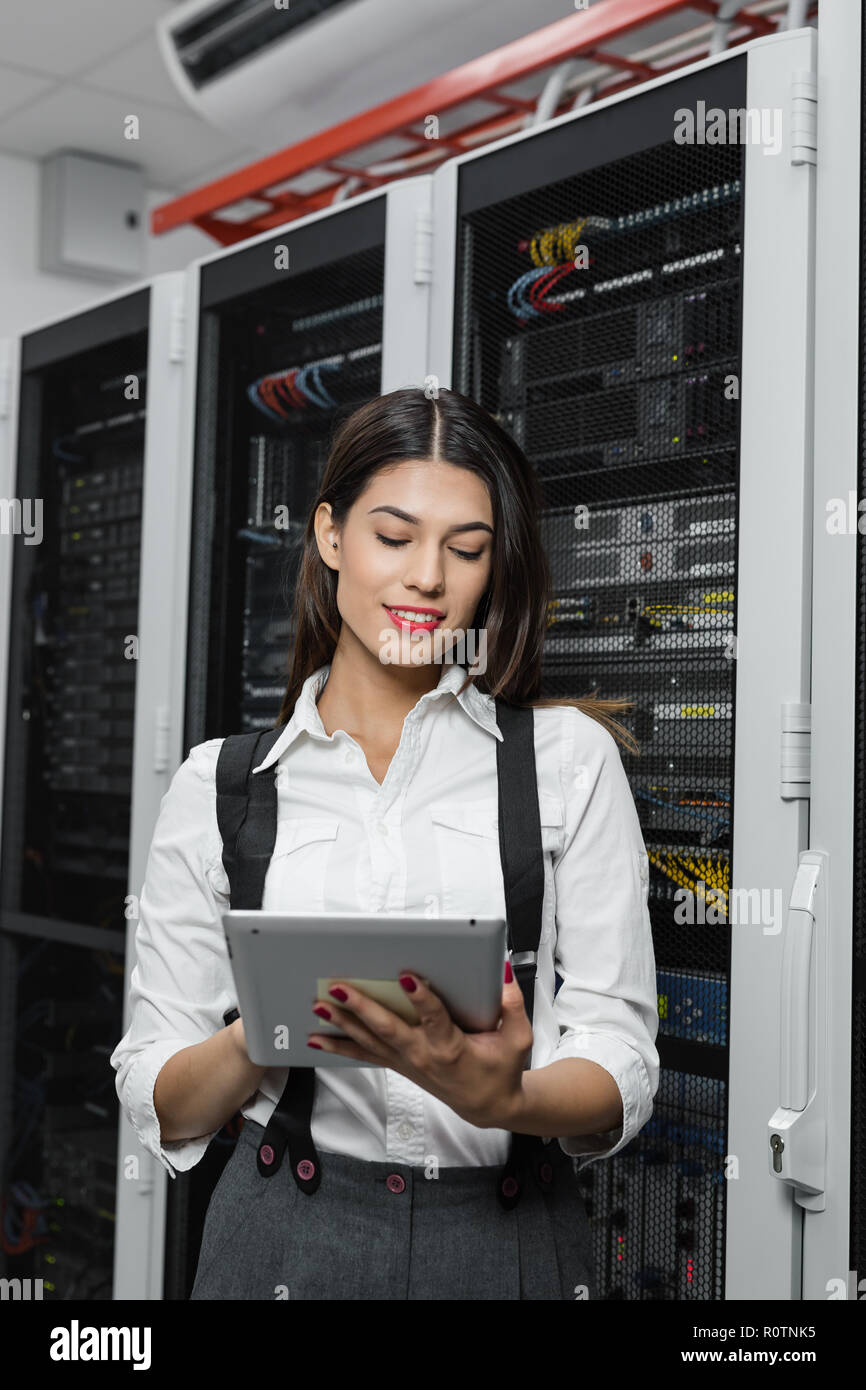 Technician apecialist woman using laptop while analyzing server in server room Stock Photo