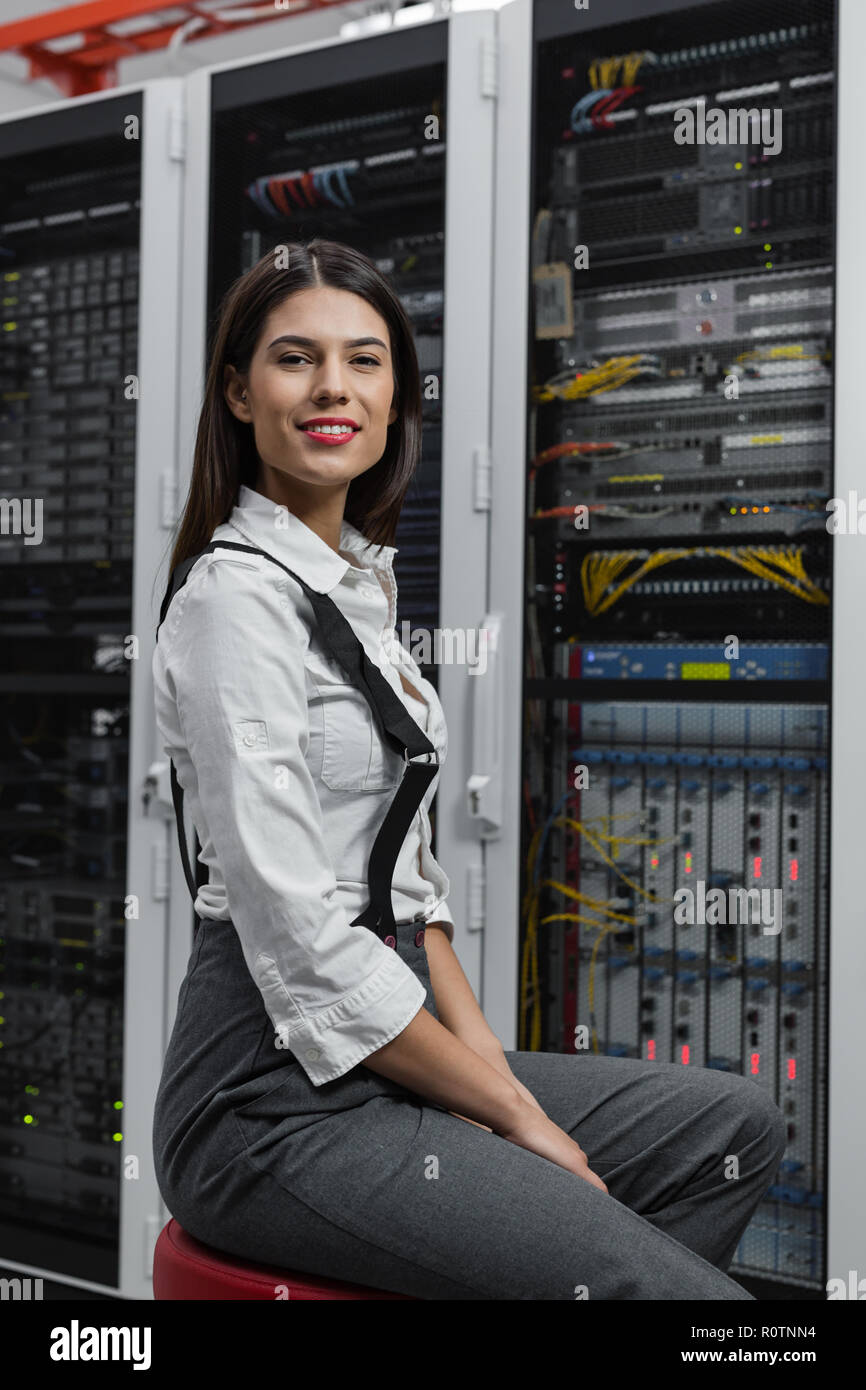 Technician apecialist woman using laptop while analyzing server in server room Stock Photo