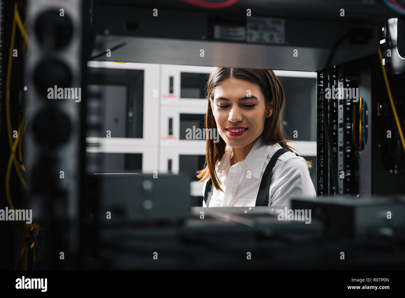 Technician apecialist woman using laptop while analyzing server in server room Stock Photo