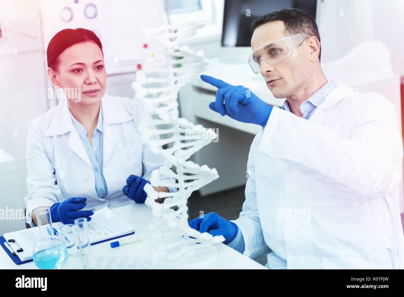 Nice adult man pointing at the DNA model Stock Photo
