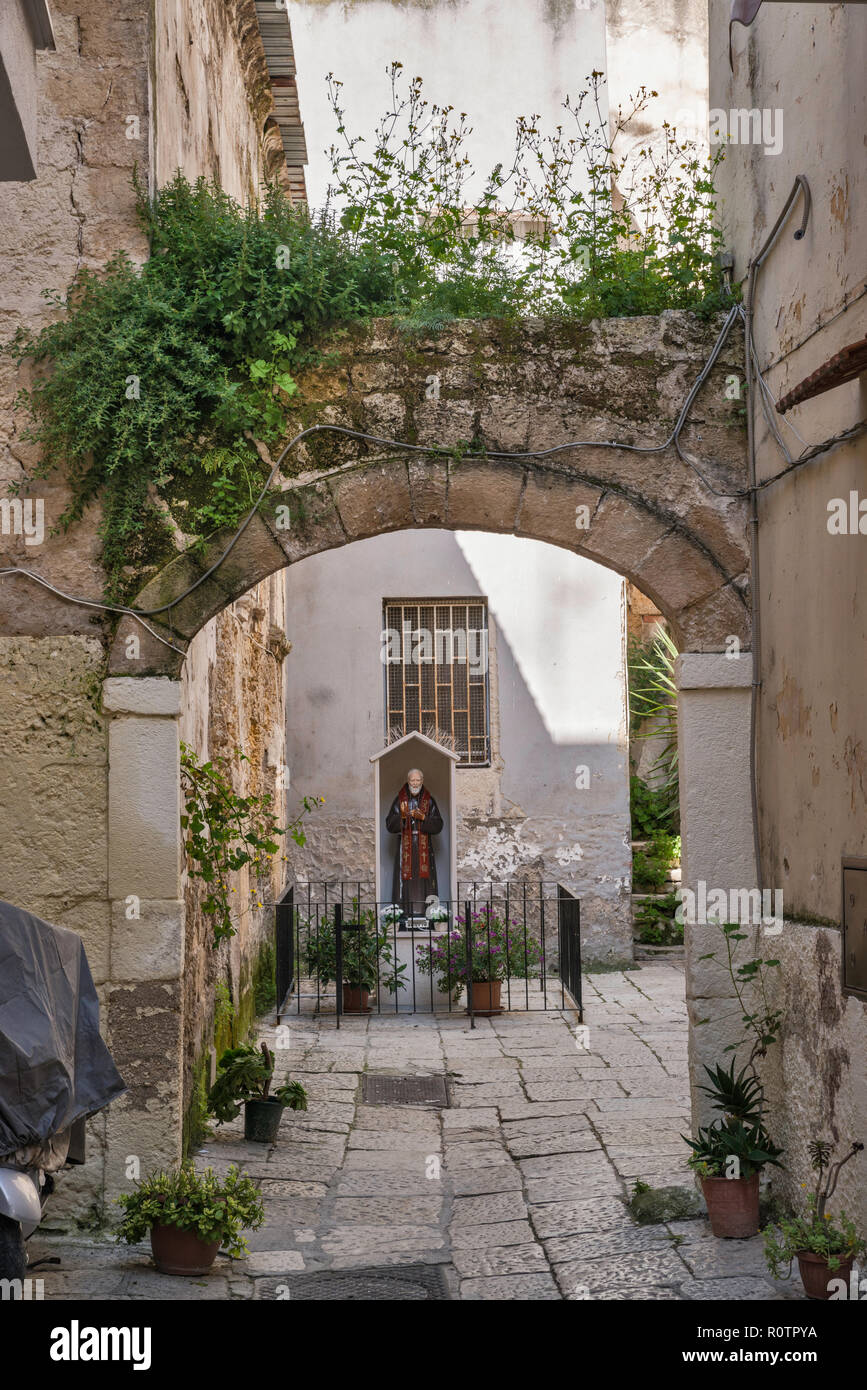 Buttress over courtyard, Saint Pio image, Corte Alberolungo, in historic center of Bari, Apulia, Italy Stock Photo