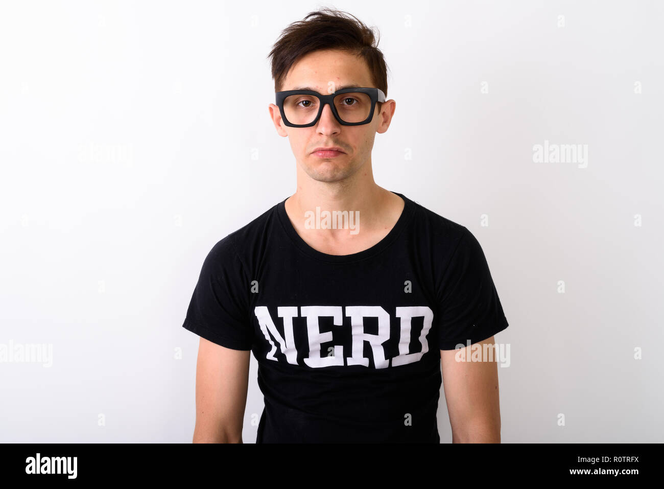 Studio shot of young nerd man wearing eyeglasses against white b Stock Photo