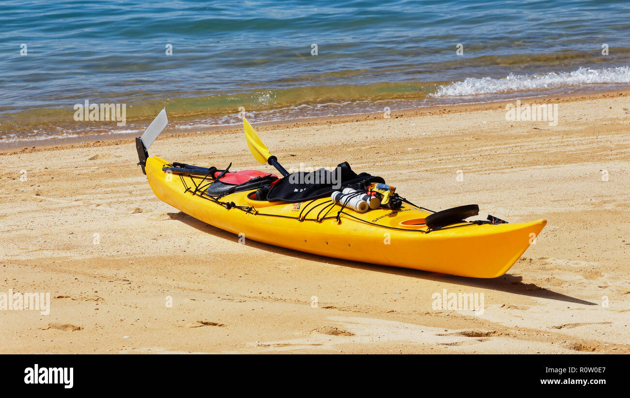 Yellow sea kayak pulled up onto the golden sandy beach, Abel Tasman ...