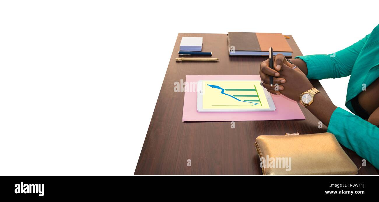 An African business woman sitting at his office table as he discusses business on a table with jotter, pen, tablet with a white background. Stock Photo