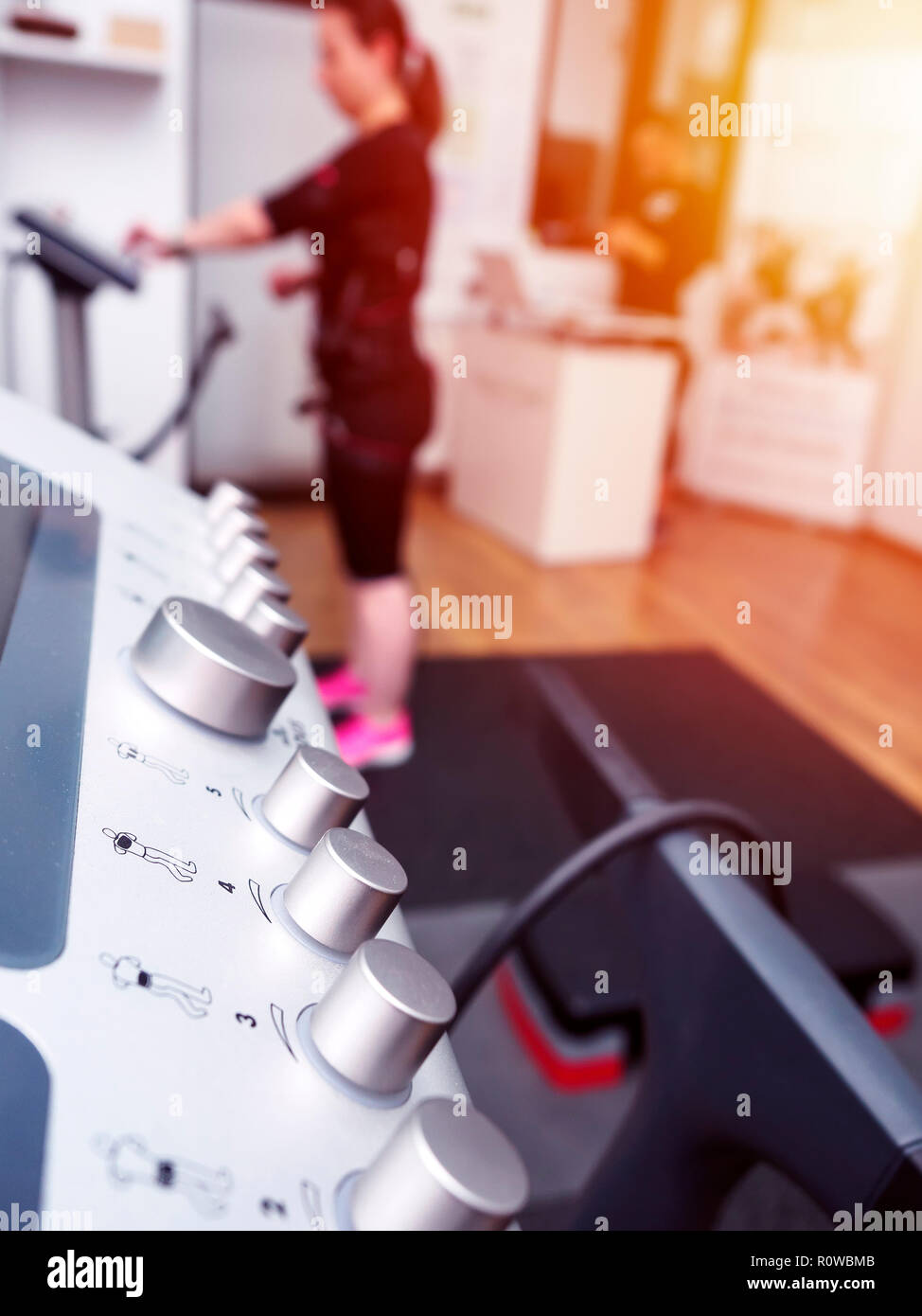 Close up of EMS with woman in electro muscular stimulation suit training Stock Photo