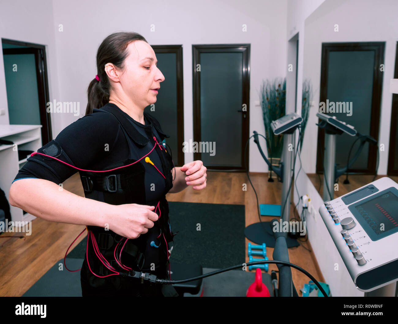 Woman in electro muscular stimulation suit training Stock Photo