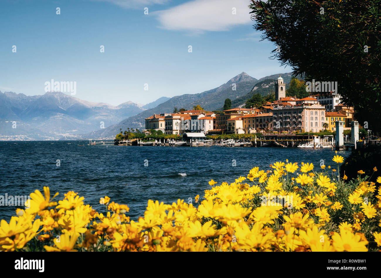 Cityscape of Bellagio with colorful luxury buildings and yellow flowers, lake Como, Lombardy region, Italy Stock Photo