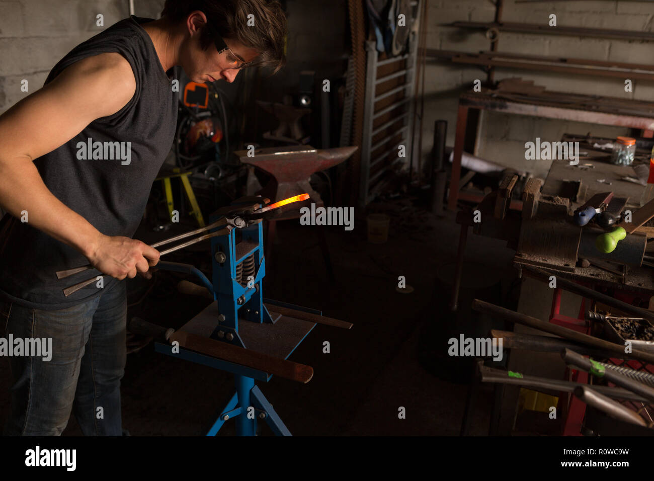 Female metalsmith shaping horseshoe in factory Stock Photo Alamy