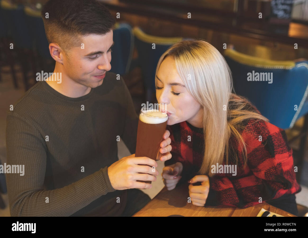 Couple drinking beer in restaurant Stock Photo
