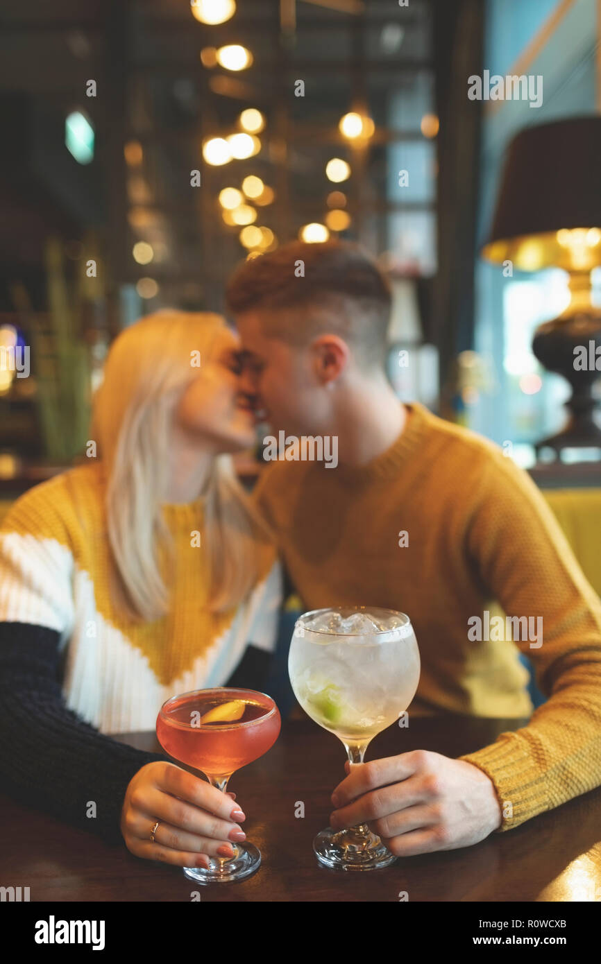 Couple kissing and holding cocktail glass Stock Photo