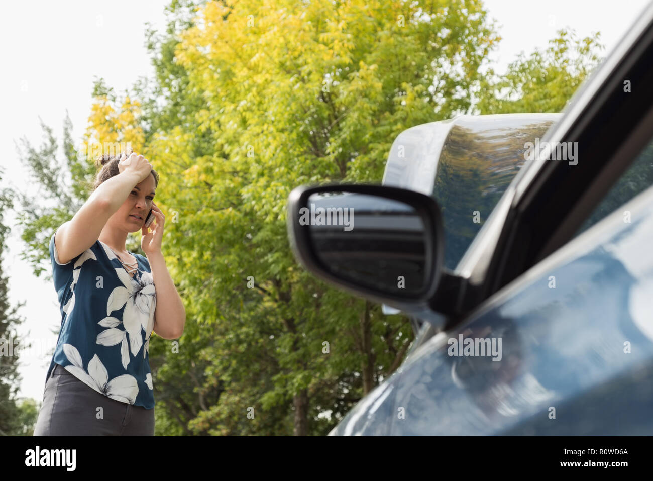 Woman talking on mobile phone during car breakdown Stock Photo