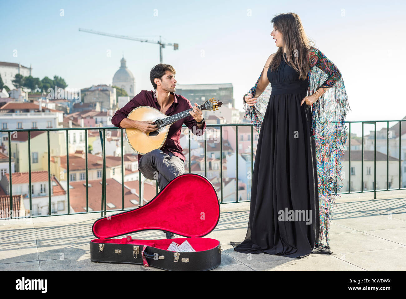Beautiful fado singer performing with handsome portuguese guitarist player in Alfama, Lisbon, Portugal Stock Photo