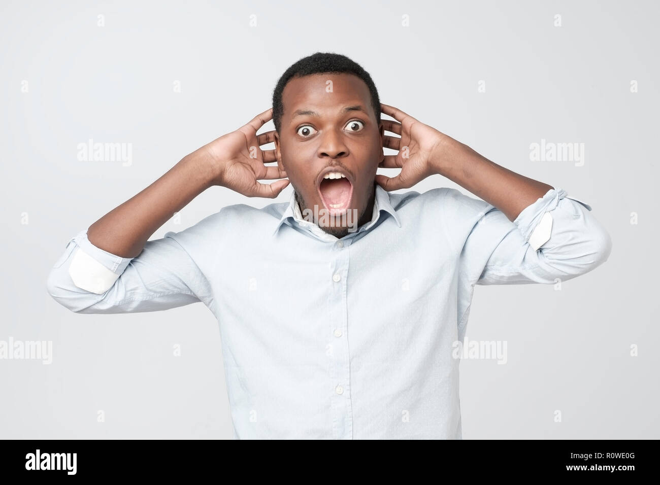 Portrait of african young handsome man surprised with news he got. Stock Photo