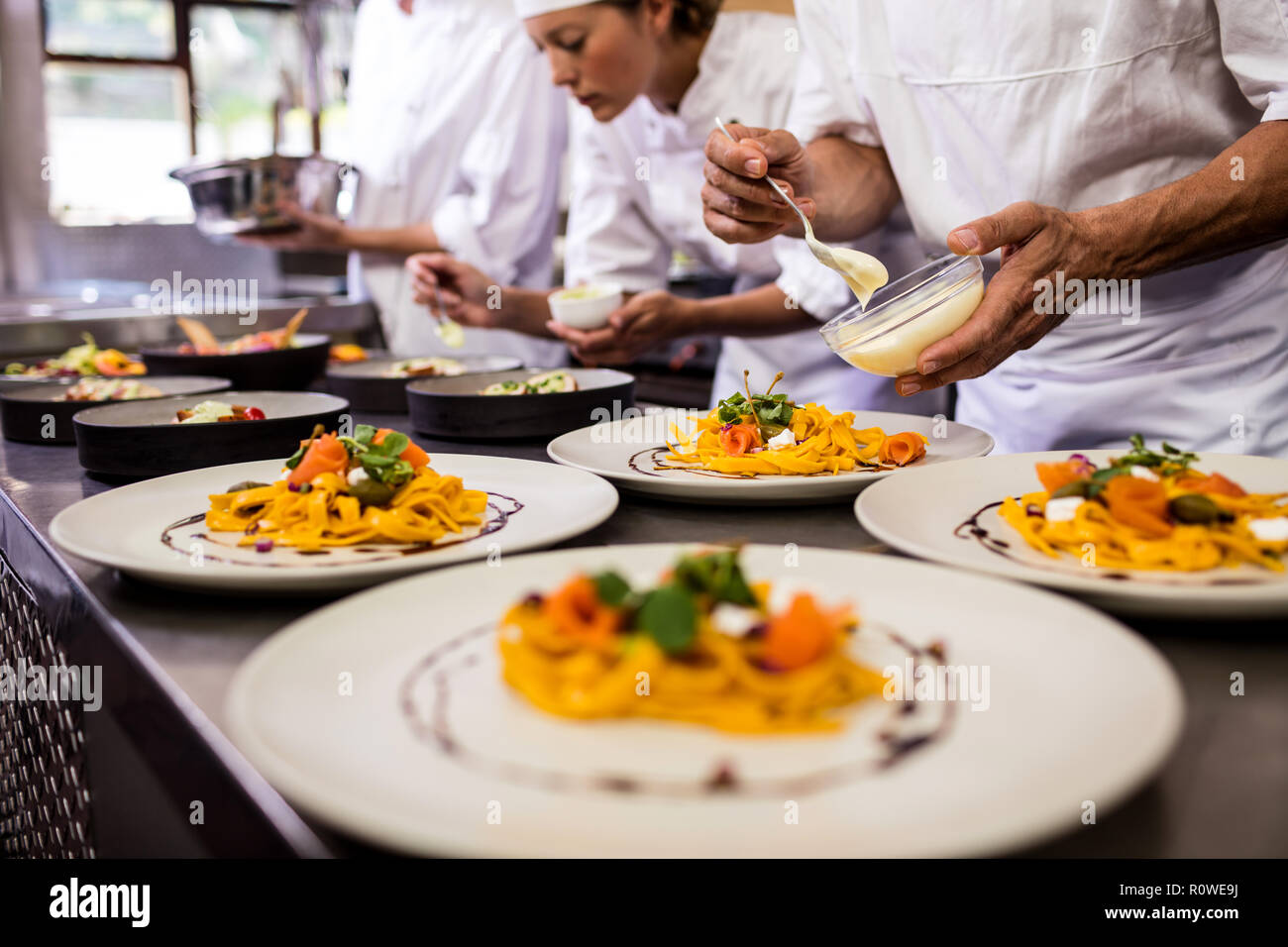 https://c8.alamy.com/comp/R0WE9J/chef-garnishing-food-on-plates-R0WE9J.jpg