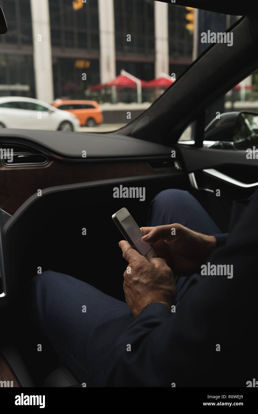 Businessman using mobile in car Stock Photo