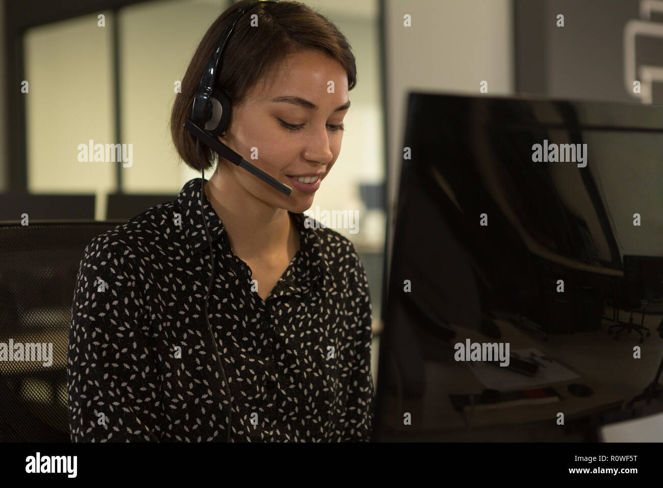 Customer service executive talking on headset at desk Stock Photo - Alamy