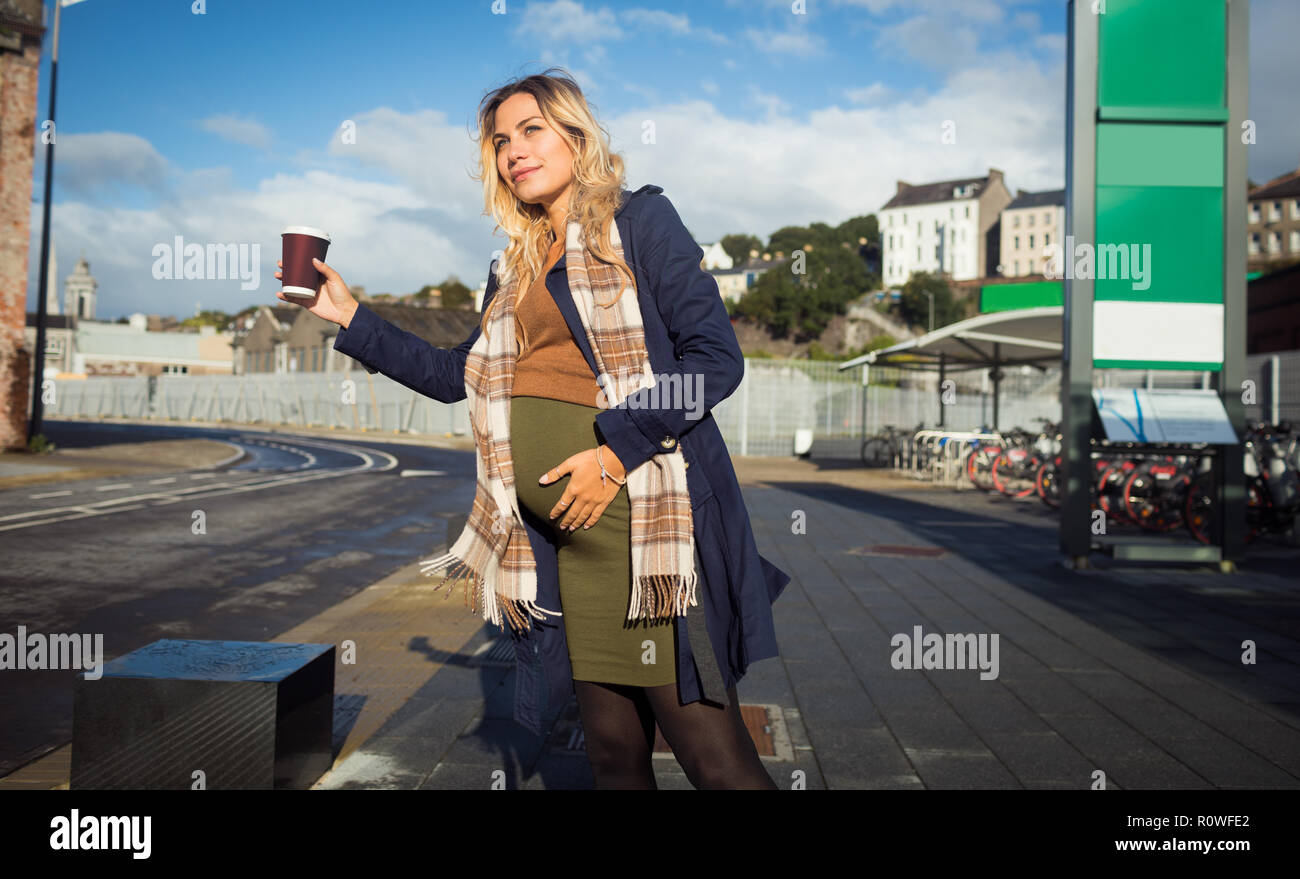 Pregnant woman waving at bus stop Stock Photo - Alamy