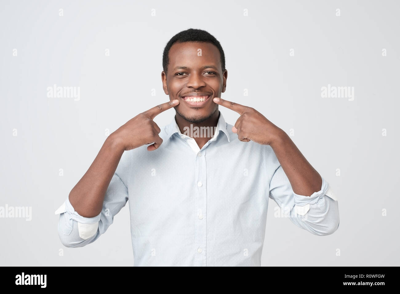African young handsome man showing his excellent white teeth. Stock Photo