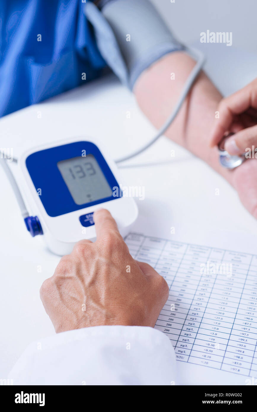 closeup of a caucasian doctor man, in a white coat, measuring the blood