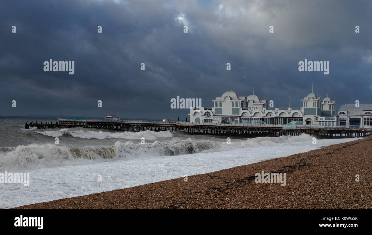 waves breaking in front of an old British seaside pier during stormy weather Stock Photo