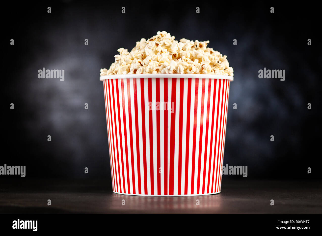 Full popcorn bucket on a dark background Stock Photo - Alamy