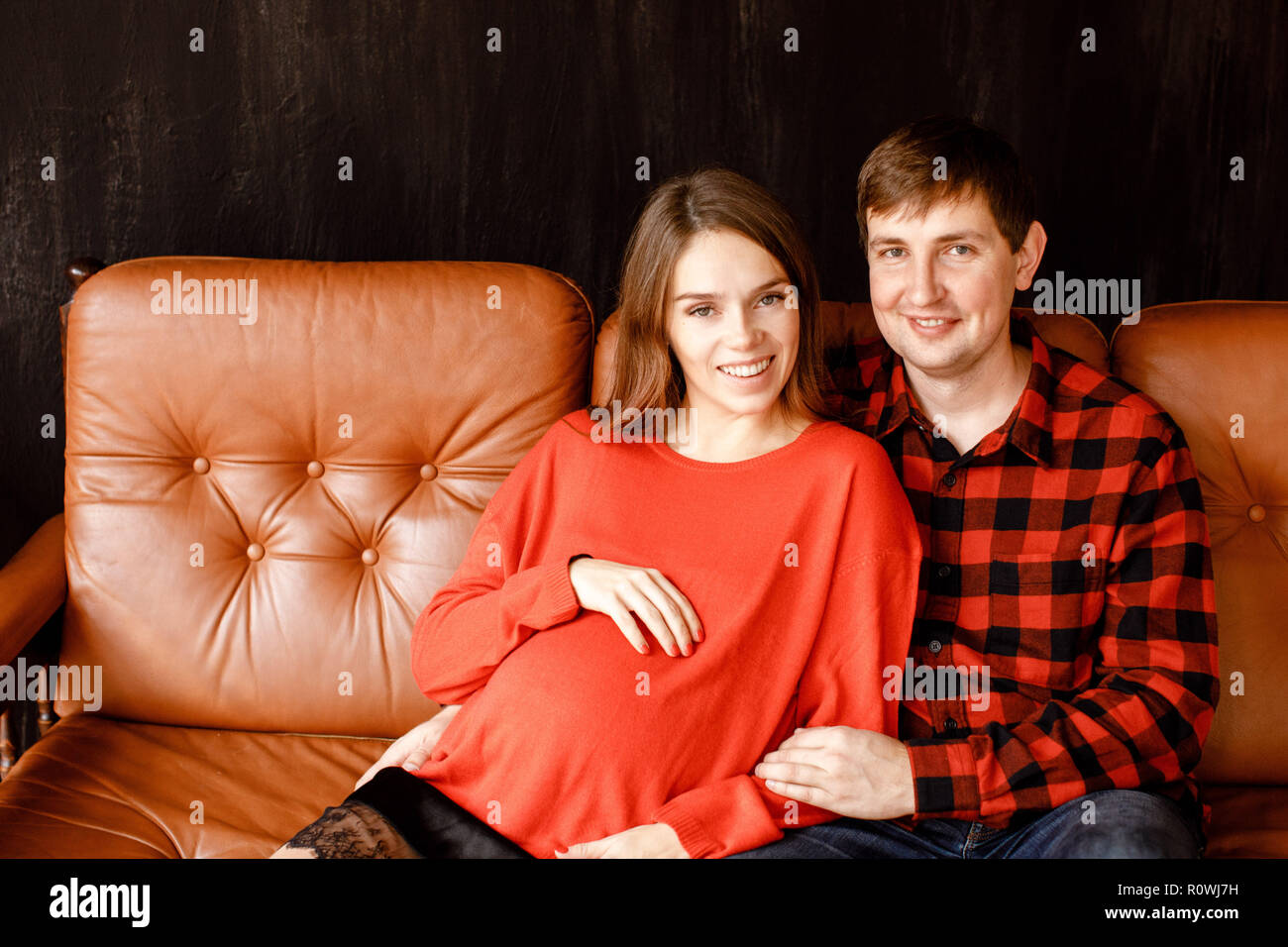 Cheerful couple sitting on sofa Stock Photo