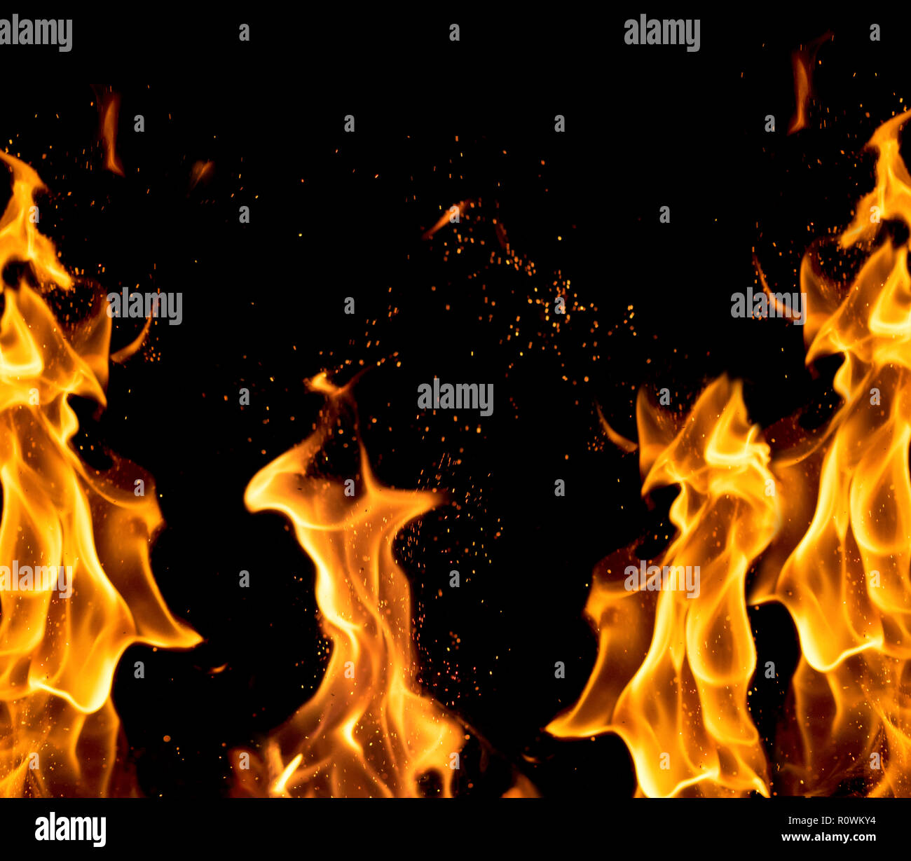 bright orange and yellow flames with sparks on a black background,close ...