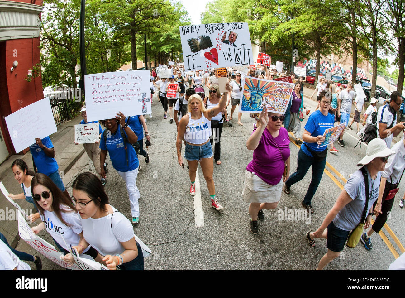People hold anti-ICE and anti-Trump signs and banners as they walk in an immigration law protest and march on June 30, 2018 in Atlanta, GA. Stock Photo
