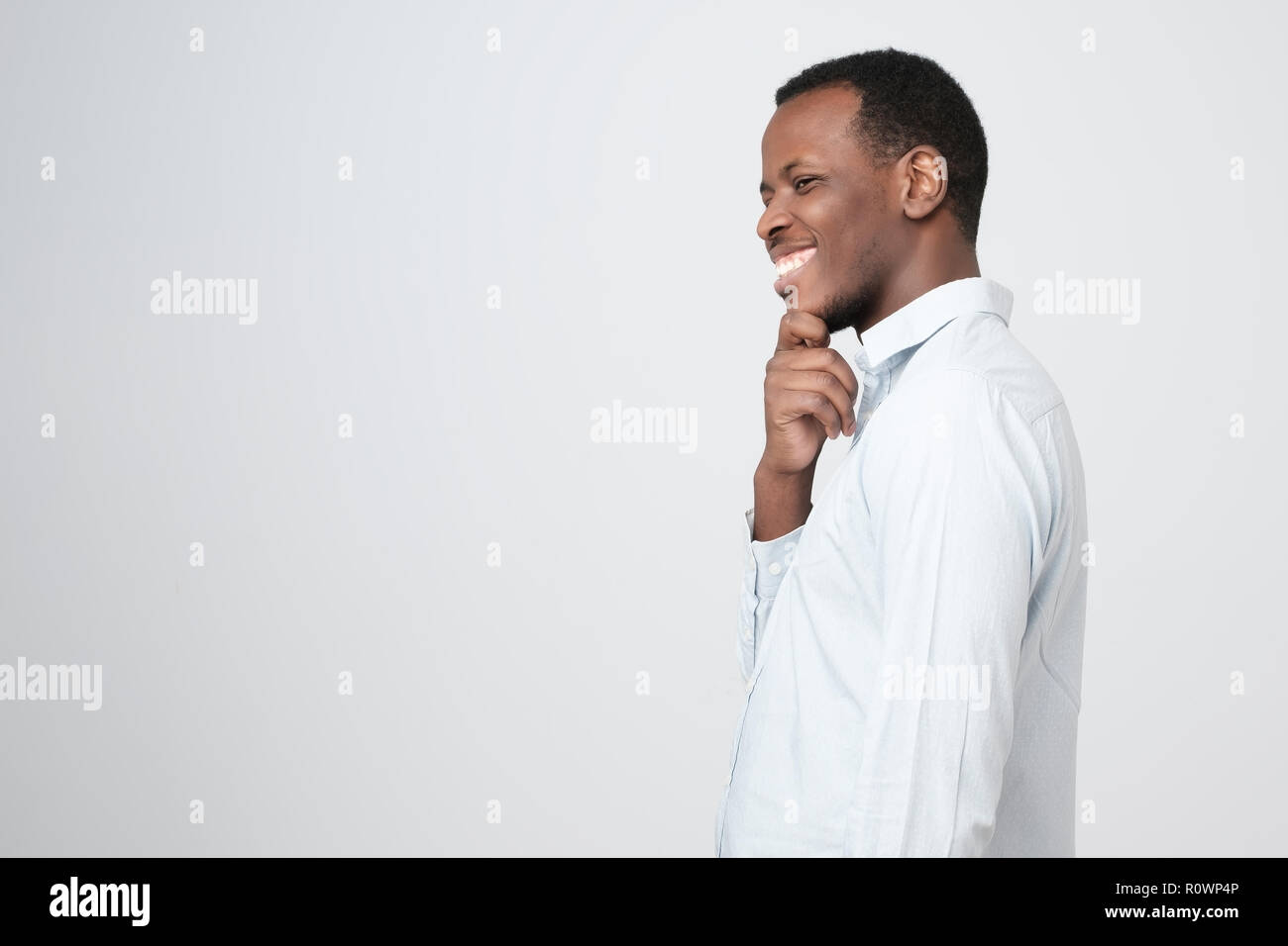 A side view of young handsome african man standing having excellent idea Stock Photo