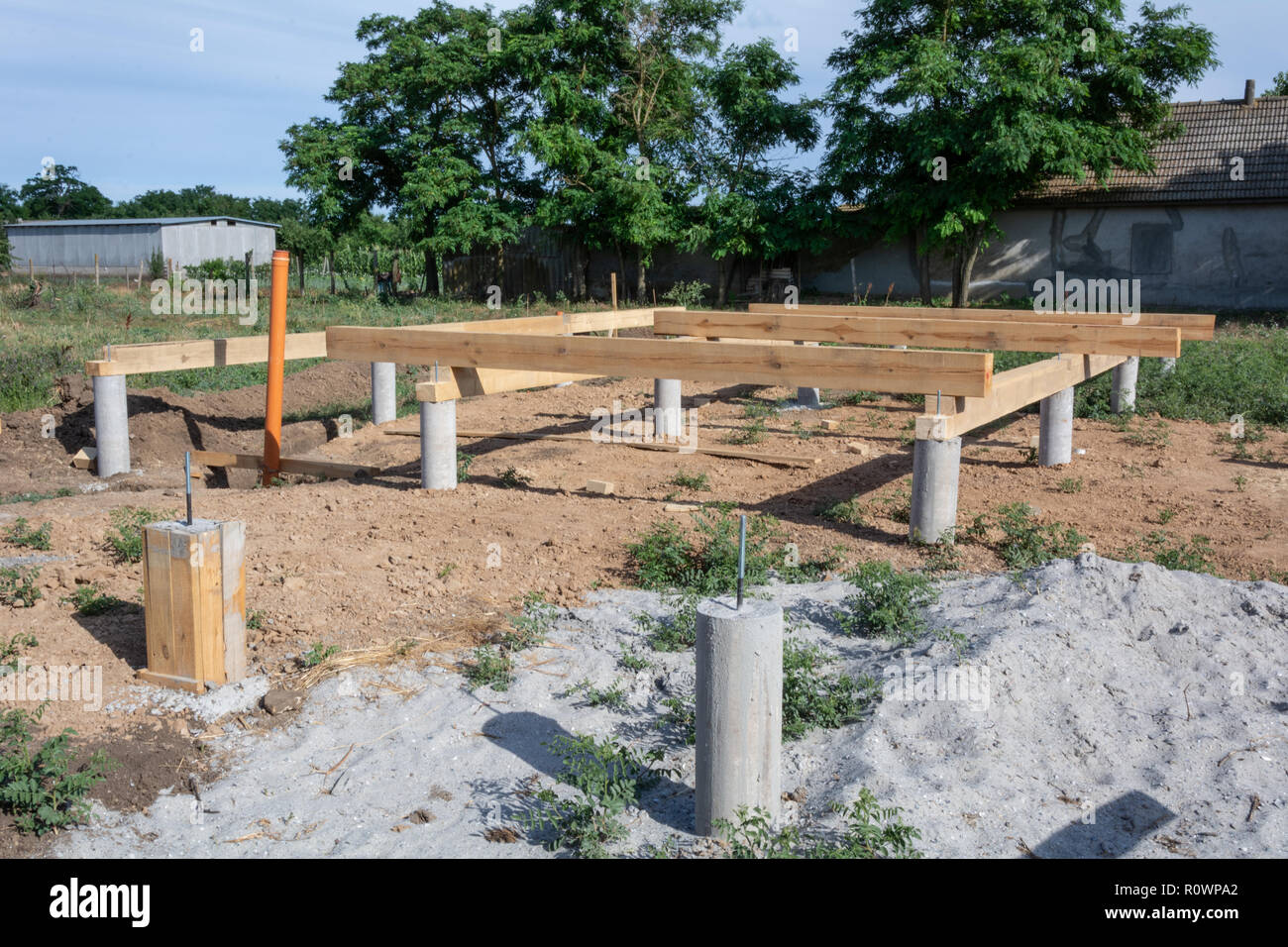 Pine wooden frame house foundation on screw piles, construction site