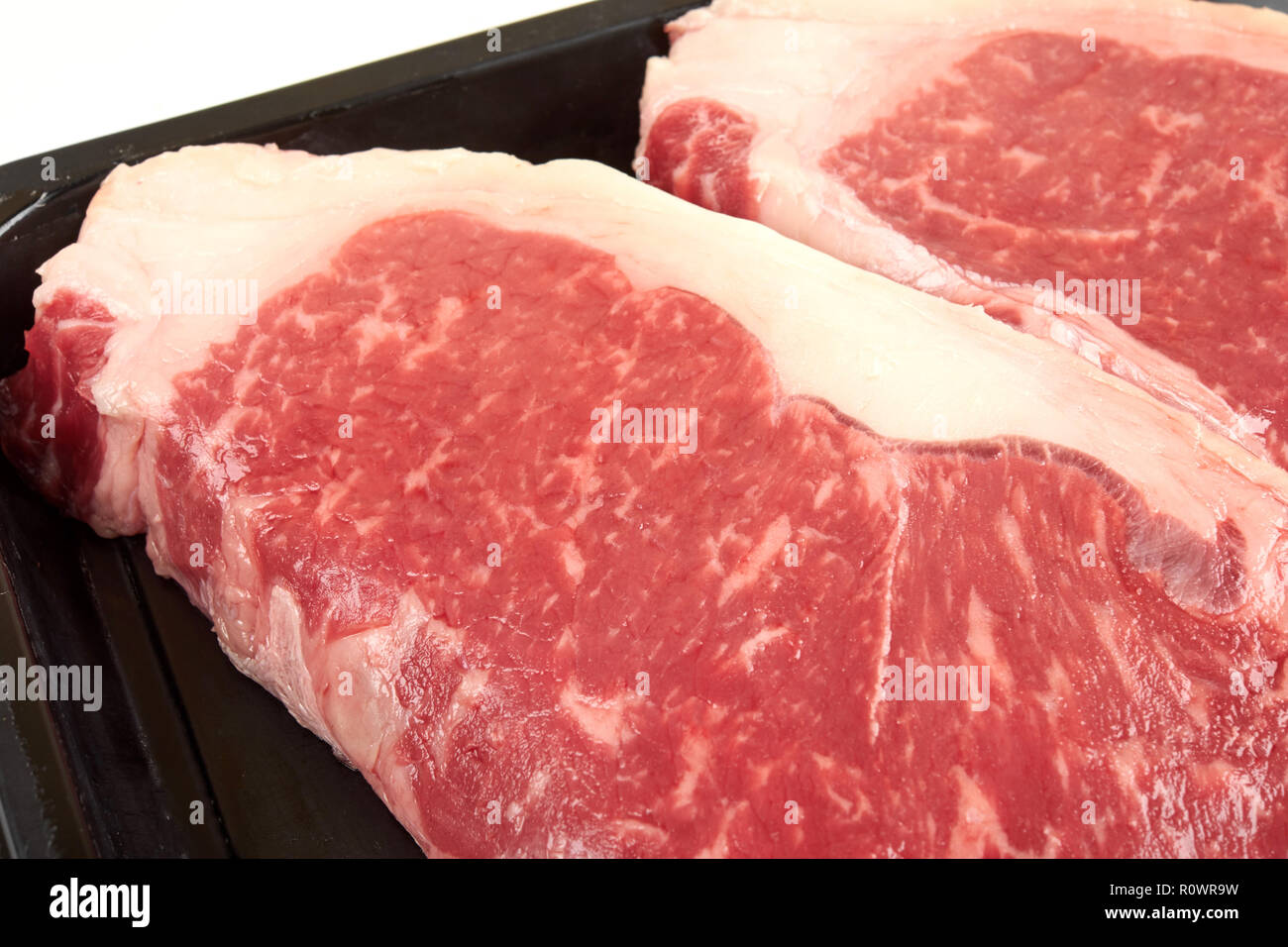 Raw sirloin beef steak in plastic packaging tray. Stock Photo