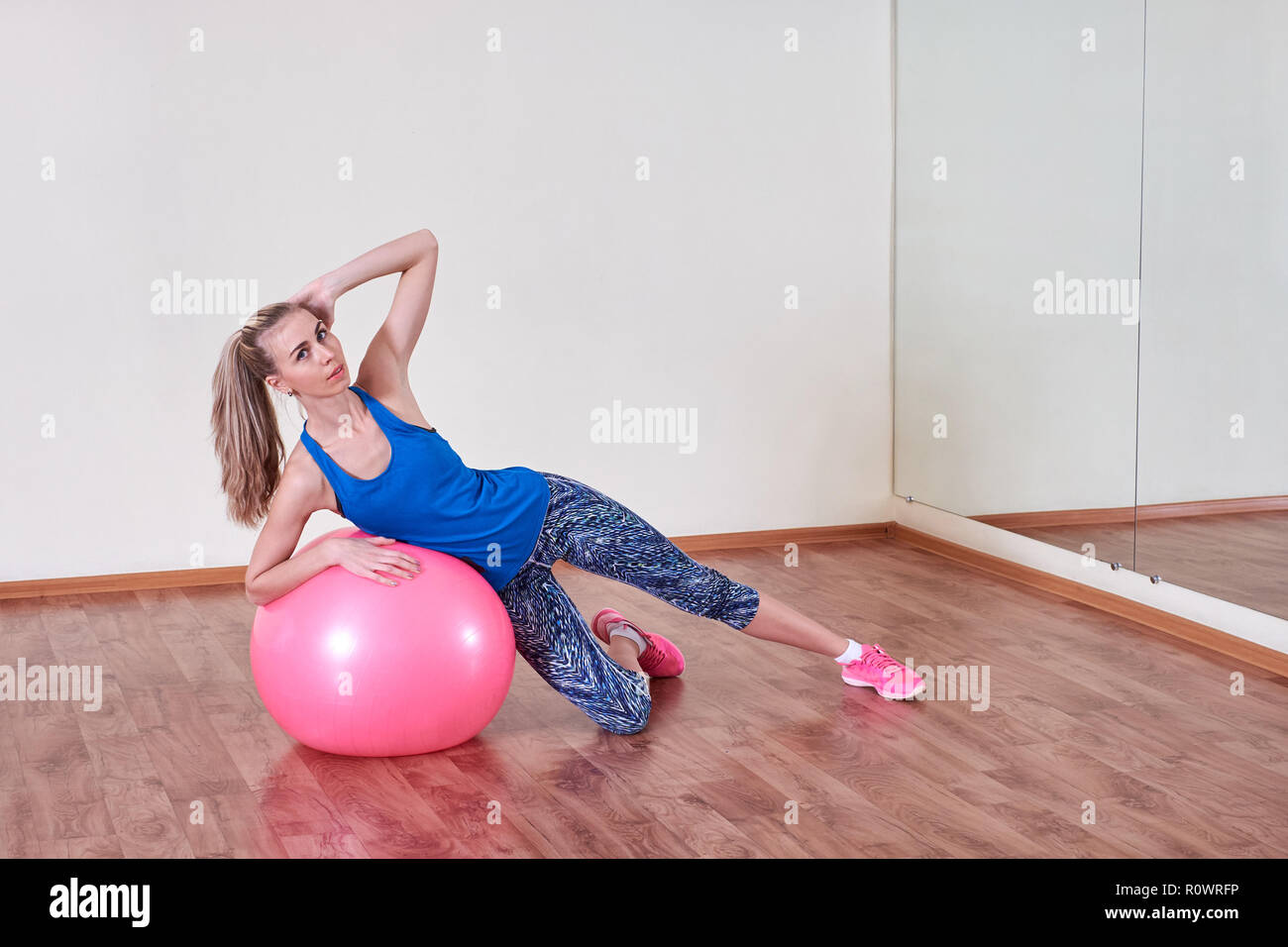 Athletic woman makes exercises on a fitness ball , indoors gym. Stock Photo