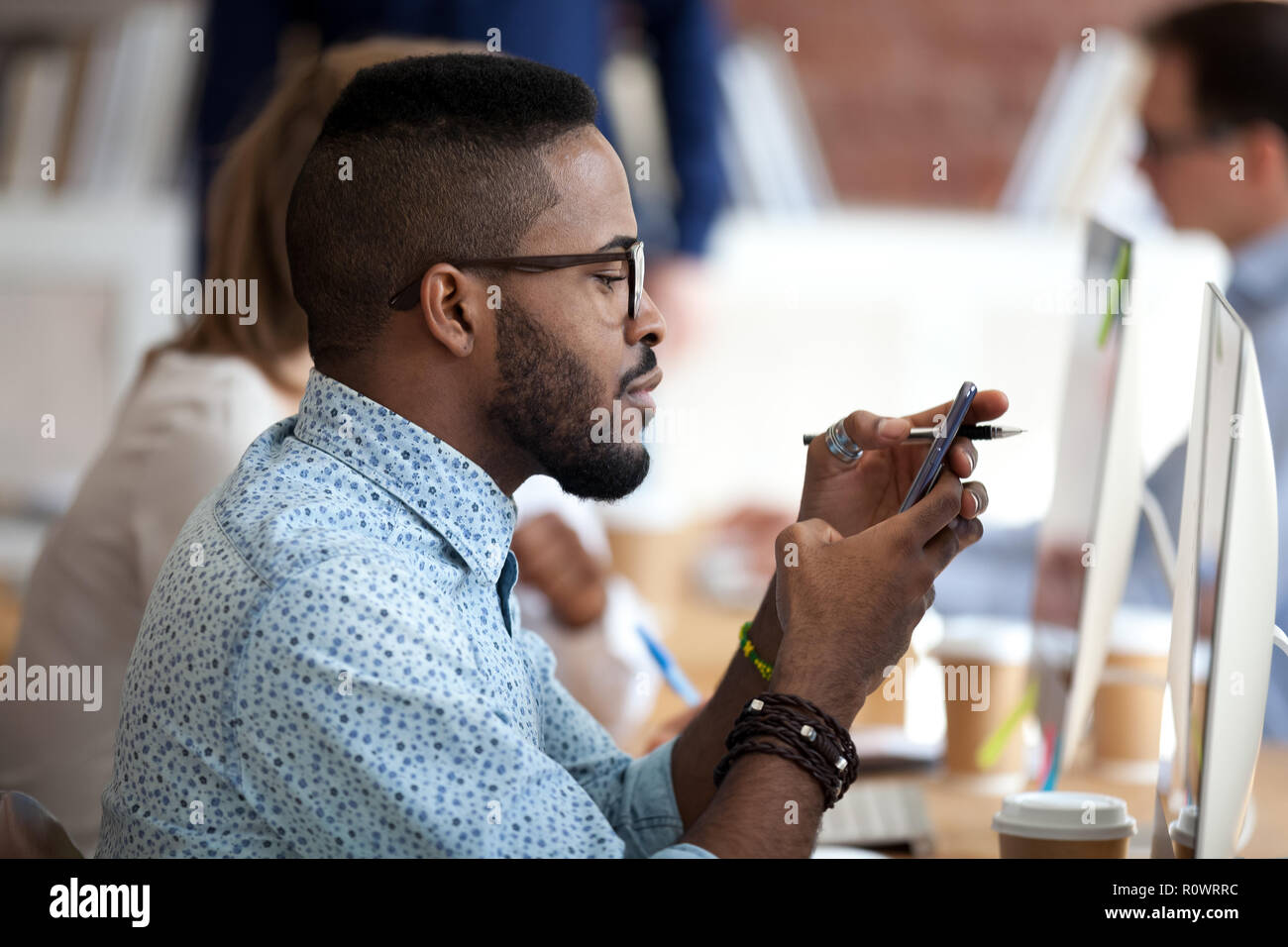 African American male worker using smartphone at work Stock Photo