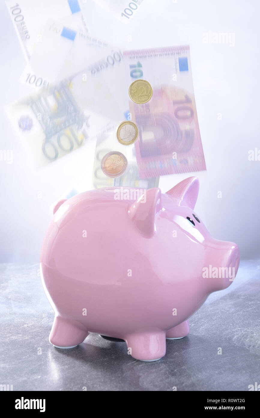Sparschwein mit fliegenden EURO-Scheinen Stock Photo