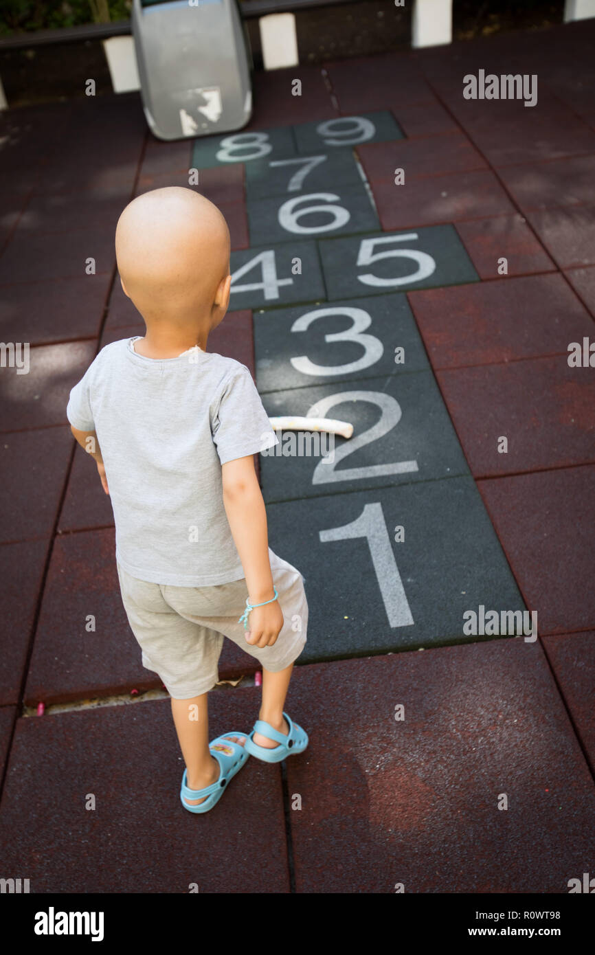 Young boy with cancer playing on playground. Stock Photo