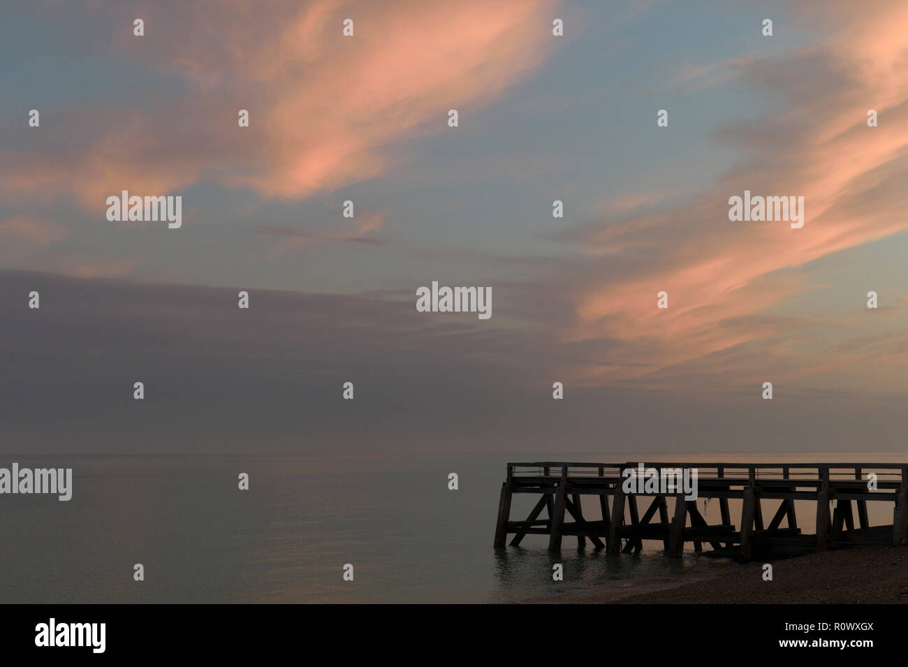 Sunrise clouds over wooden jetty, Normandy, France Stock Photo