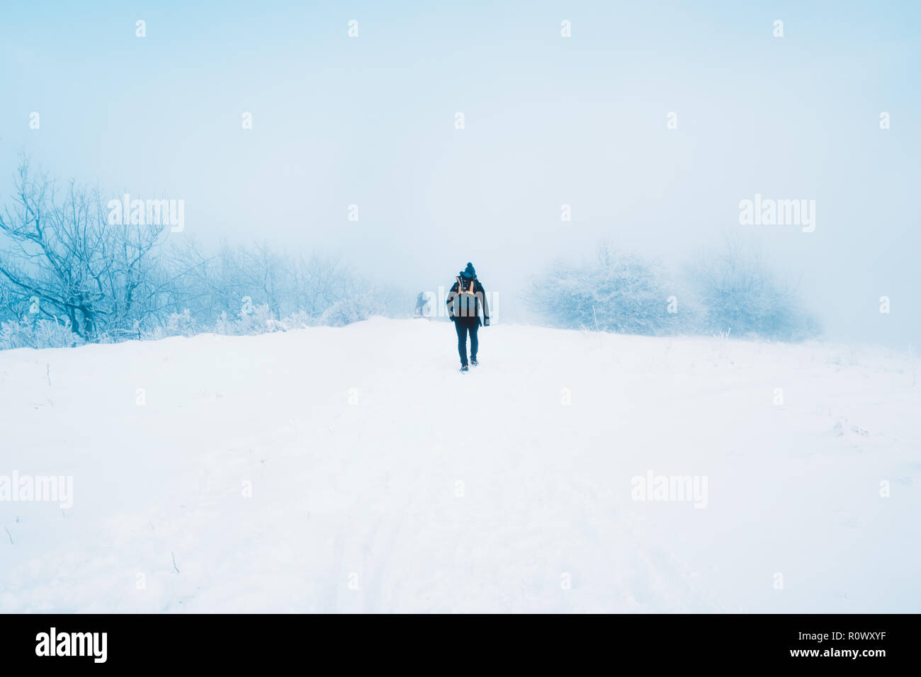 A single backpacker at the top of a snowy mountain. Stock Photo