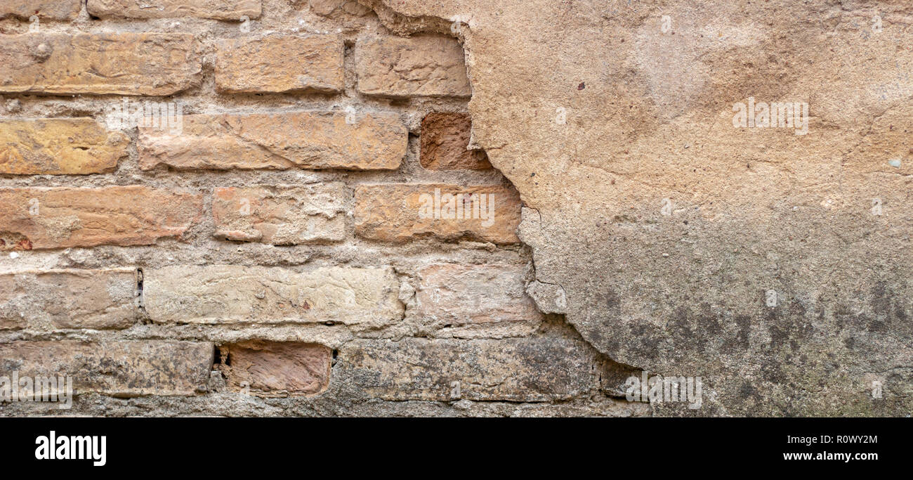 Old brick wall with peel stucco texture. Retro vintage worn wall background. Decayed cracked rough abstract wall surface Stock Photo