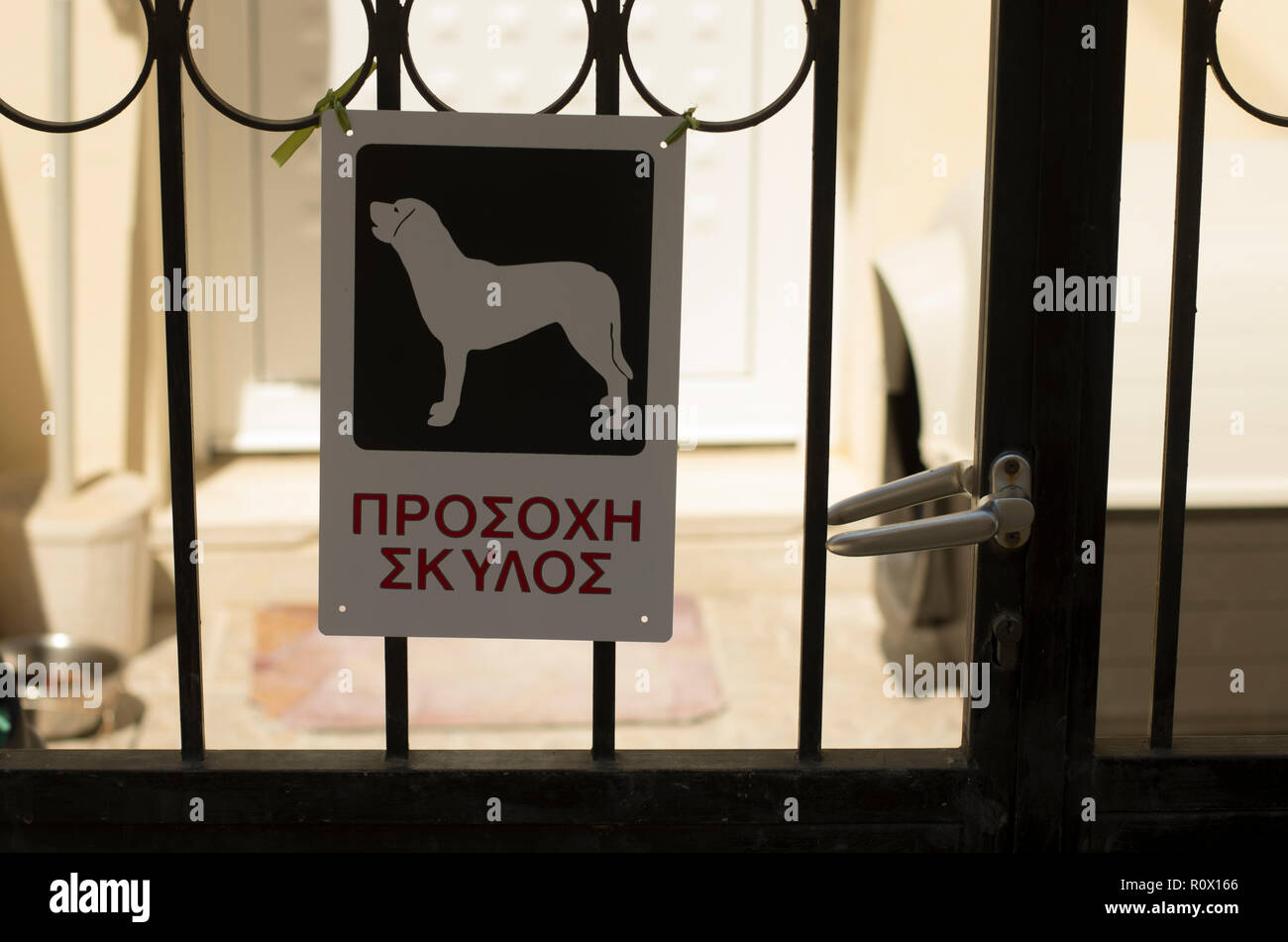 Warning sign 'Beware of dog' with the inscription in Greek on the island Crete Stock Photo