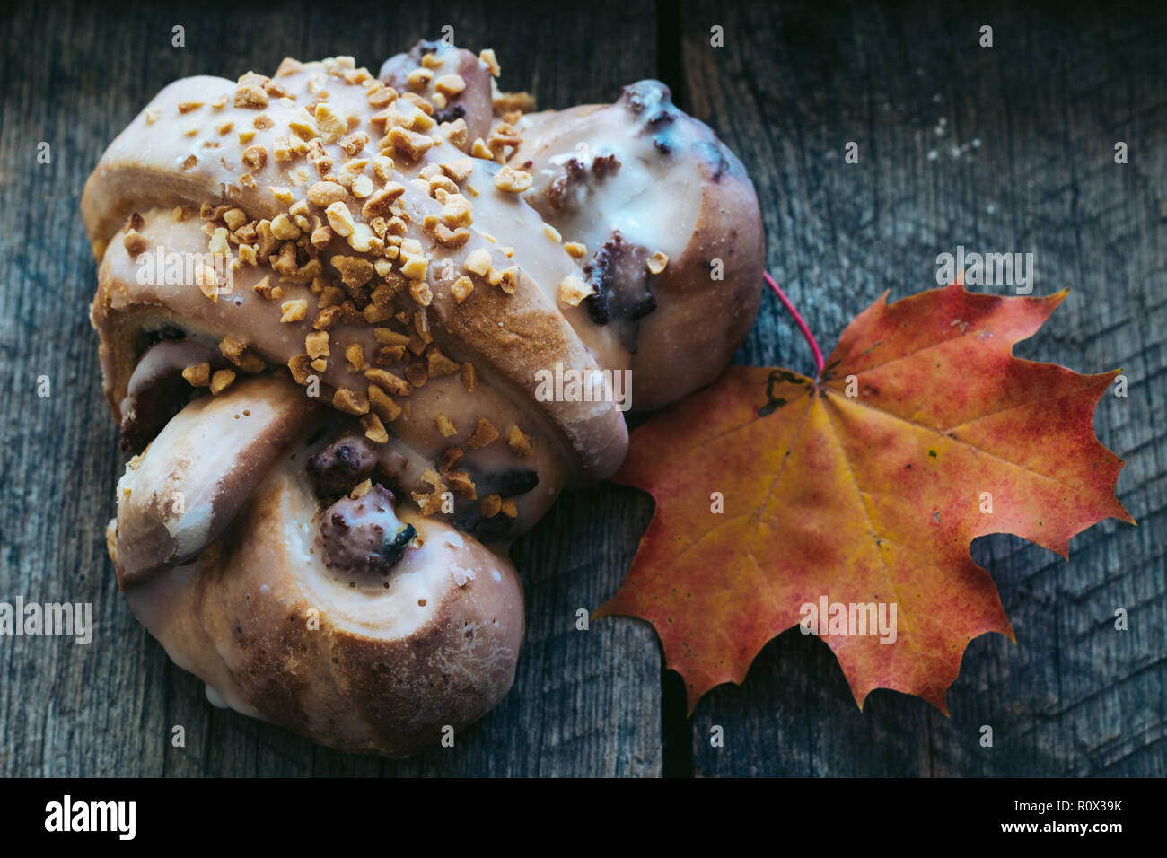 tasty polish traditional Saint Martin's croissant with white poppies, nuts and almonds called rogal swietomarcinski and wild rose fruits on wooden bac Stock Photo