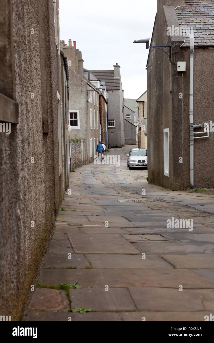 Alfred Street in Stromness, Orkney with old paving stones from a quarry in Orphir and cobble stones in the centre of the street. Stock Photo