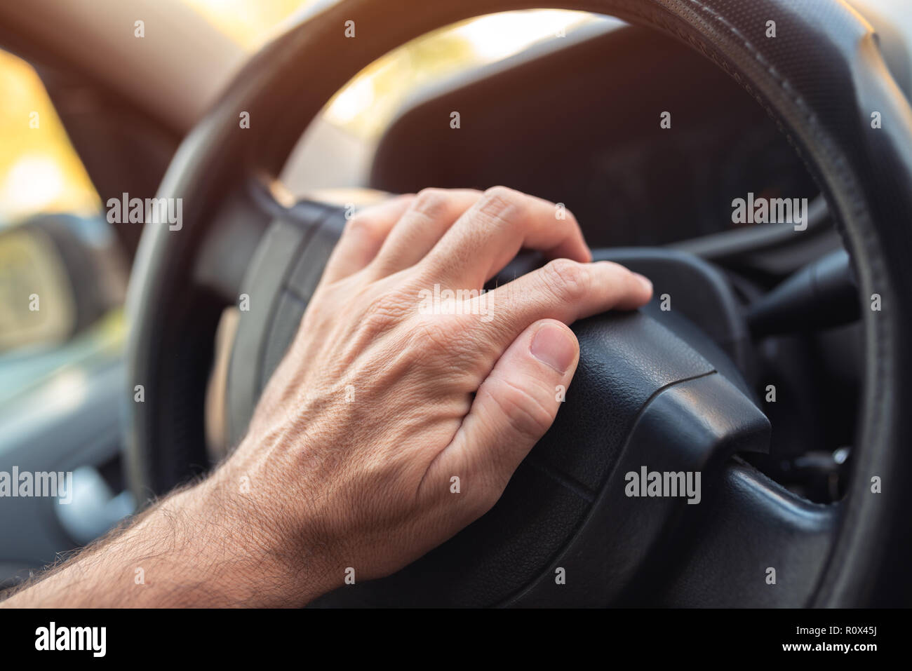Nervous driver pushing car horn on steering wheel Stock Photo