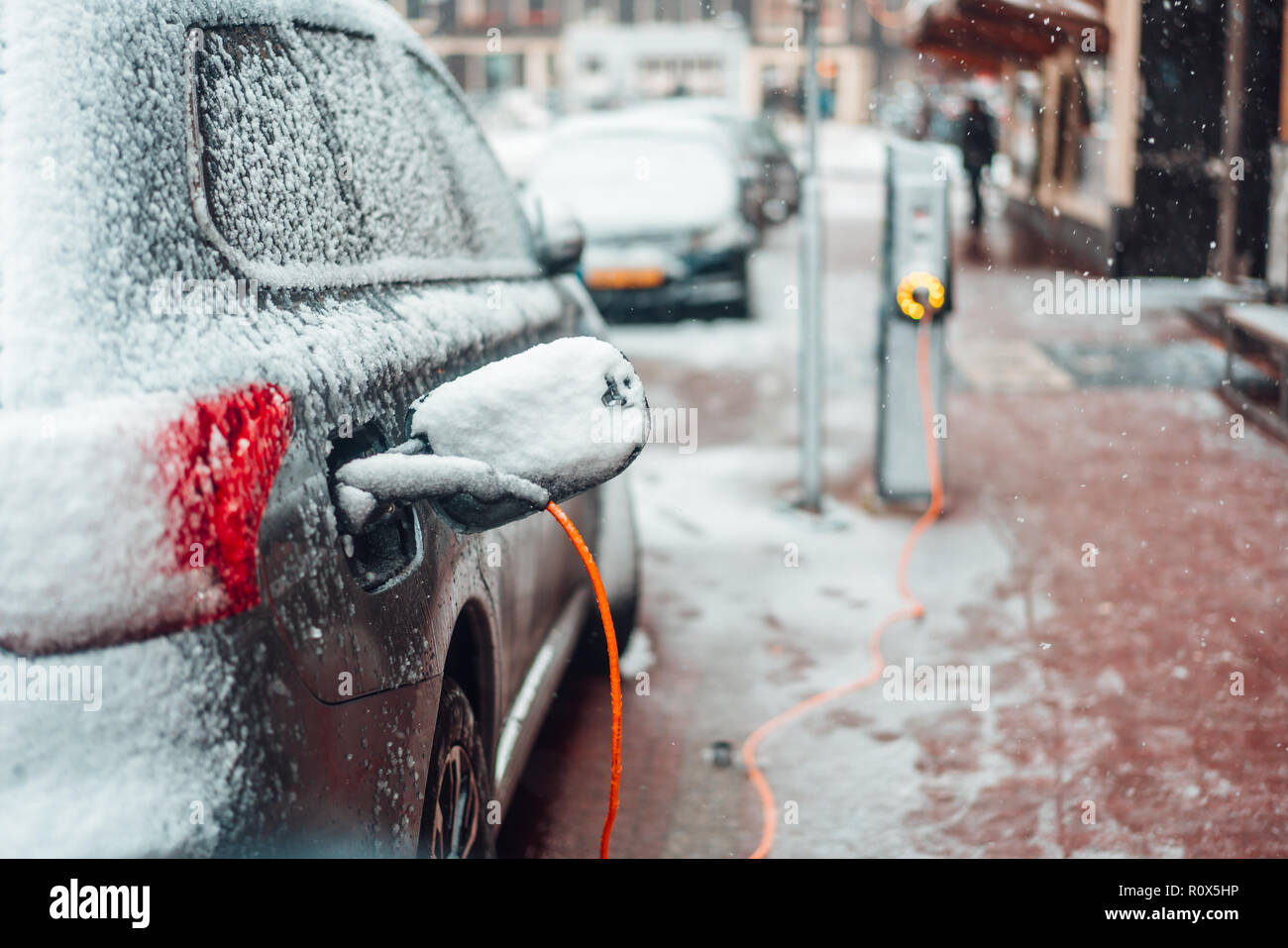 Electric car plug charging in the winter Stock Photo Alamy