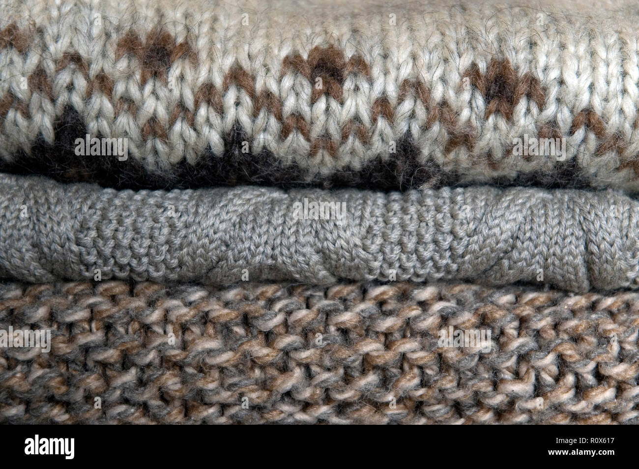 stack of natural colored woolen pullovers in wardrobe Stock Photo