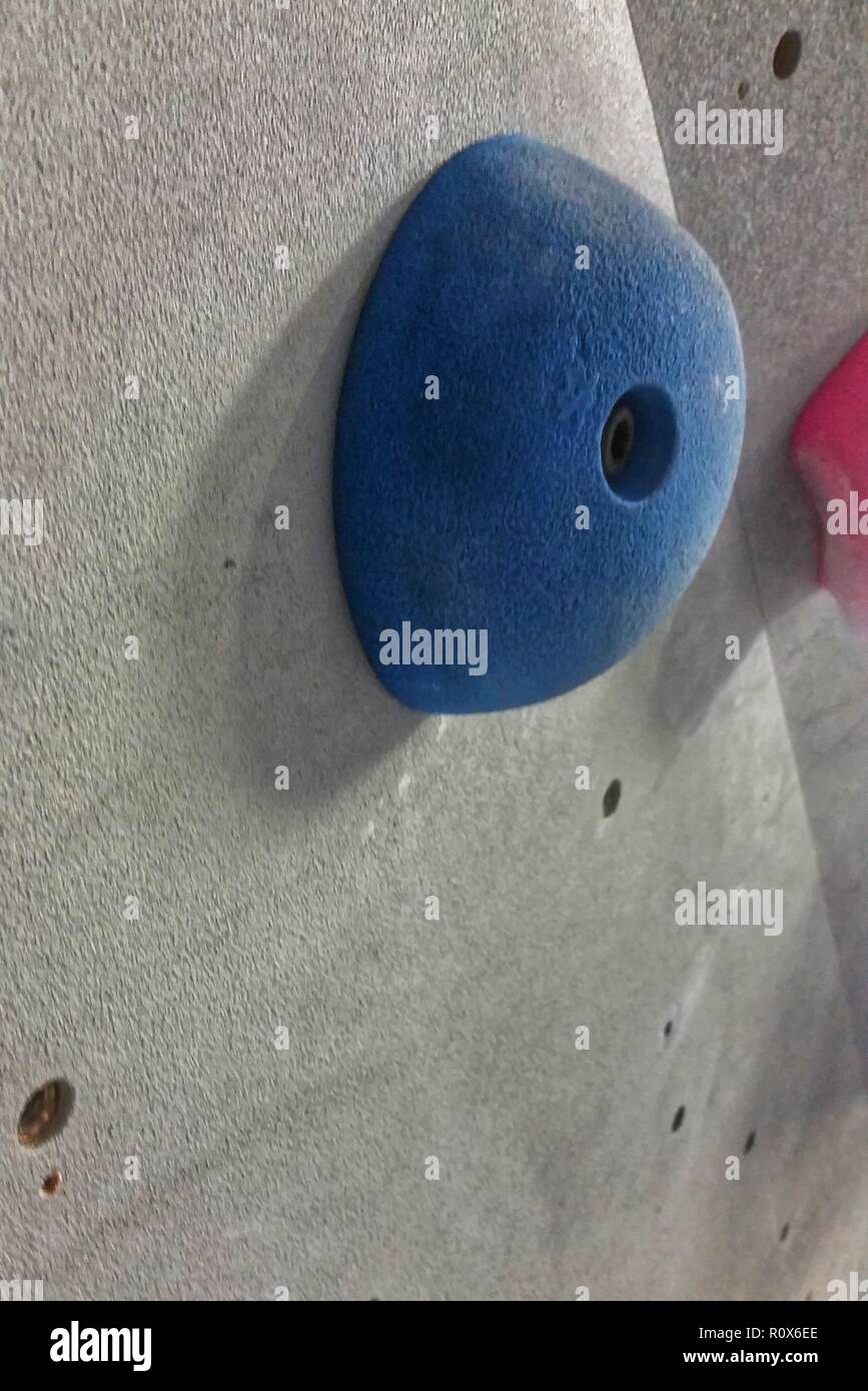 One blue sloper rock climbing hold against a grey wall Stock Photo