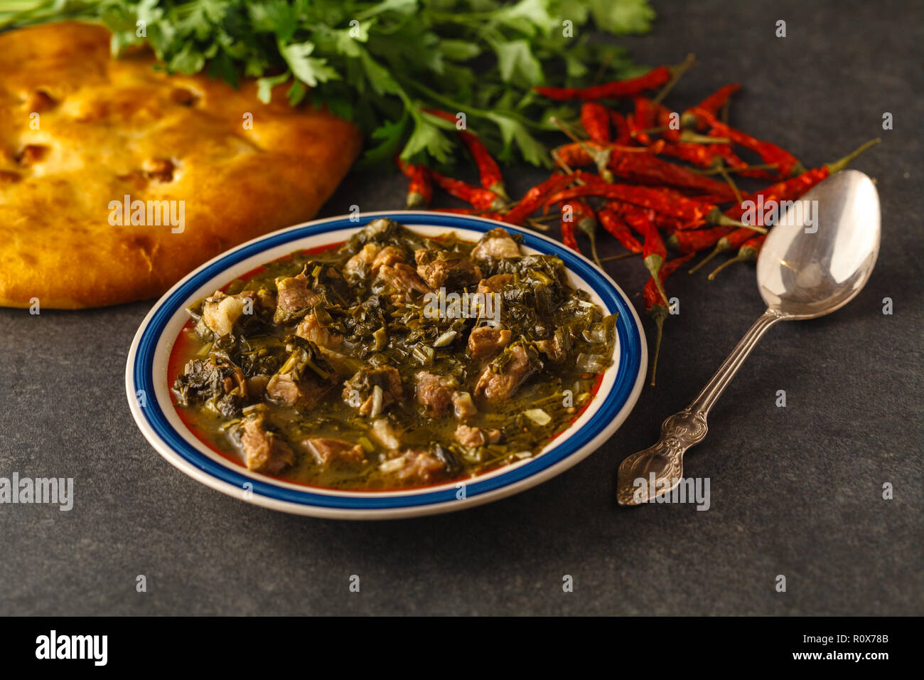 meat and greens soup from lamb with a spoon with greens Stock Photo