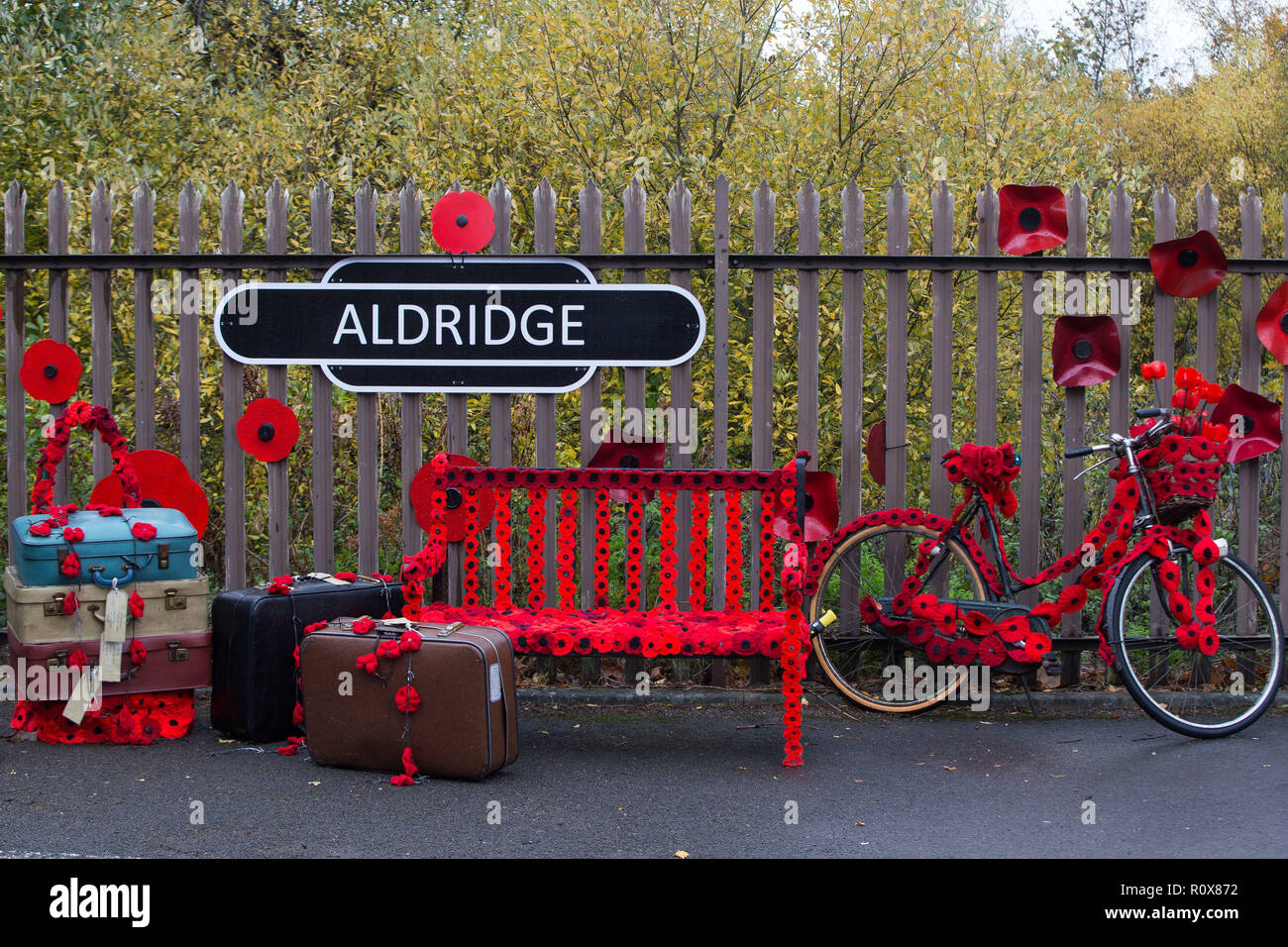 A sign in Station Road, Aldridge in Walsall which has transformed itself into Poppy Road as almost 100 houses have been decorated with 24,000 red poppies and silhouette statues of soldiers to honour local people who endured and lost their lives in the First World War. Stock Photo