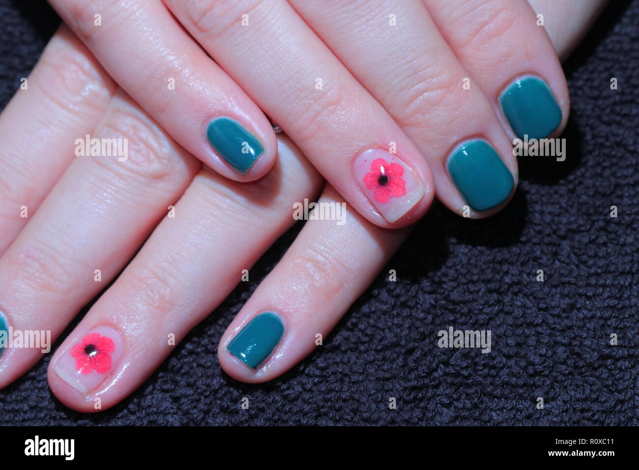 Finished gel polish on finger nails with a poppy to mark remembrance day. Stock Photo